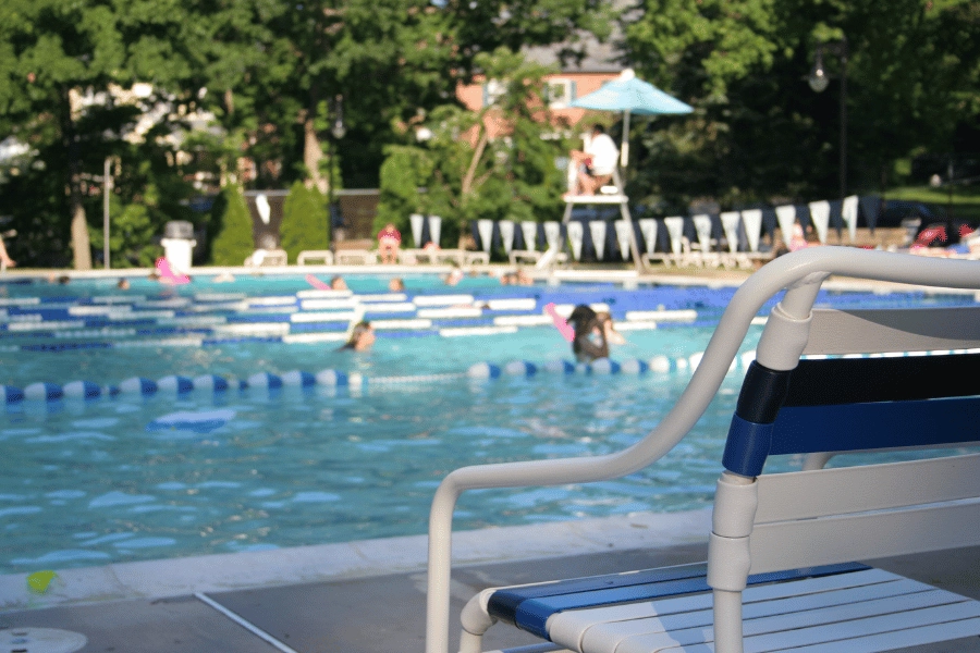 residents swimming in a community pool with a lifeguard on duty